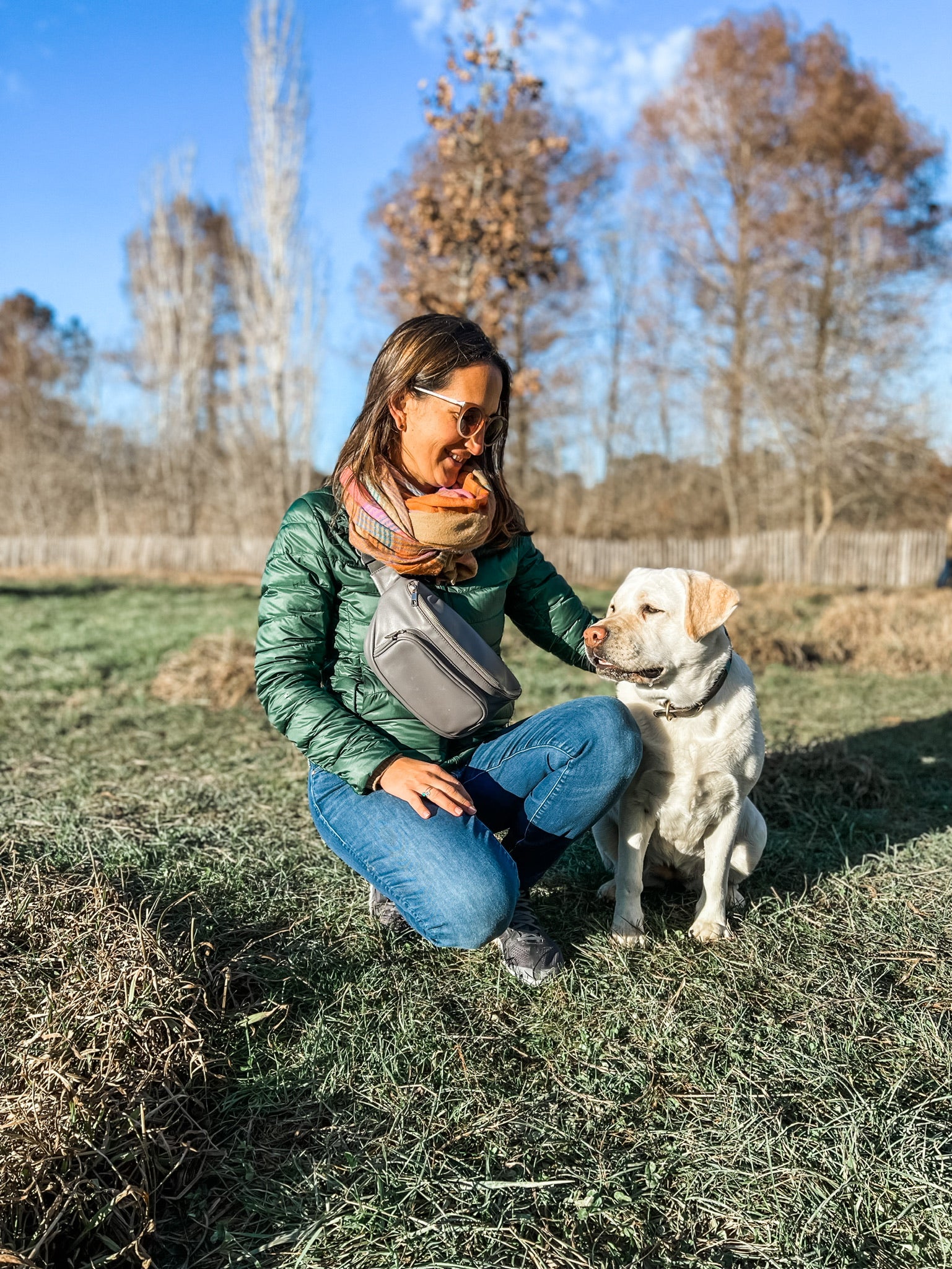 Woman wearing dog walking bag fanny pack playing with dogs